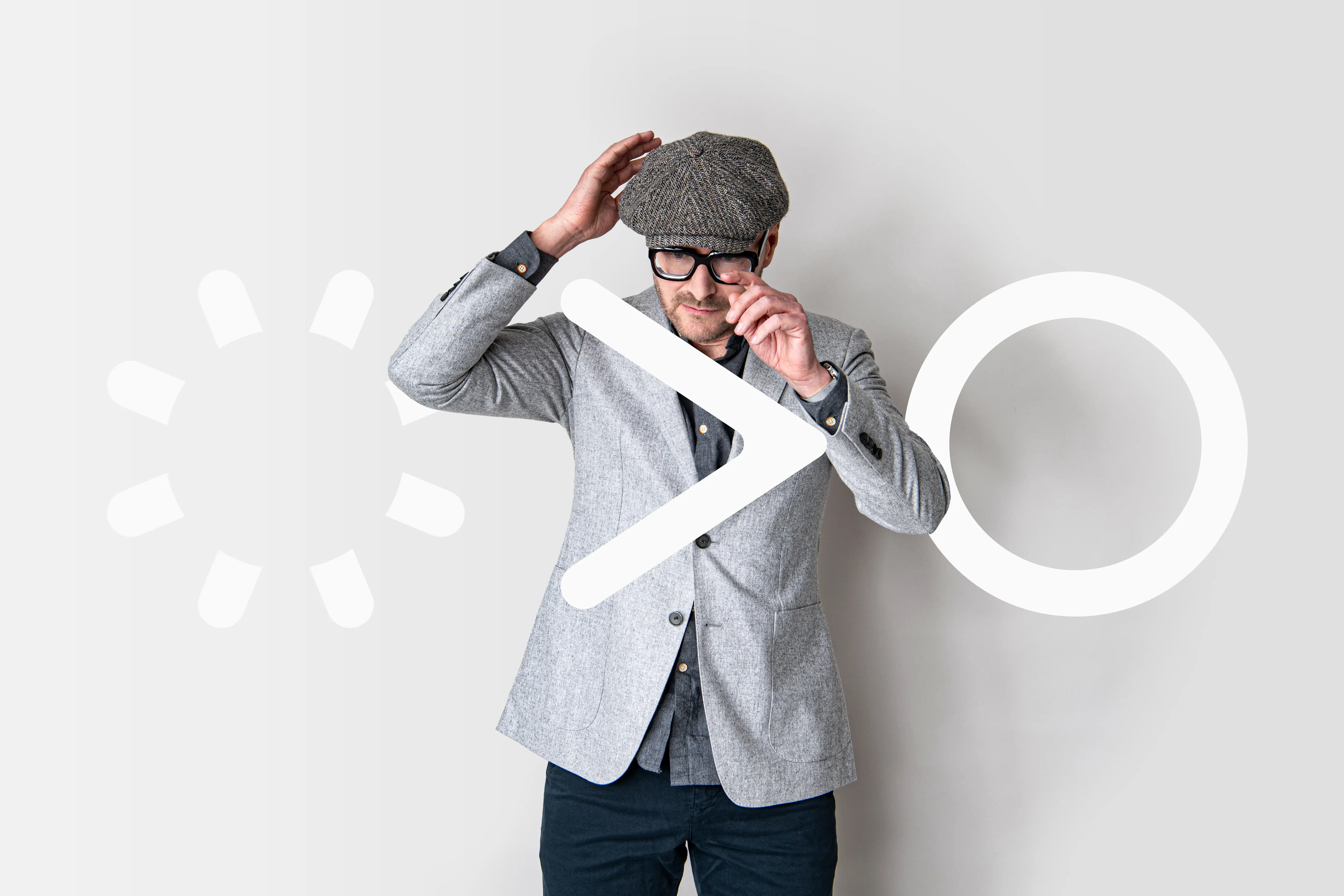 Tim Heijne van StudioPlay®, creatief bureau in Amsterdam, poseert voor een grafische achtergrond die creativiteit, branding en merkidentiteit symboliseert.