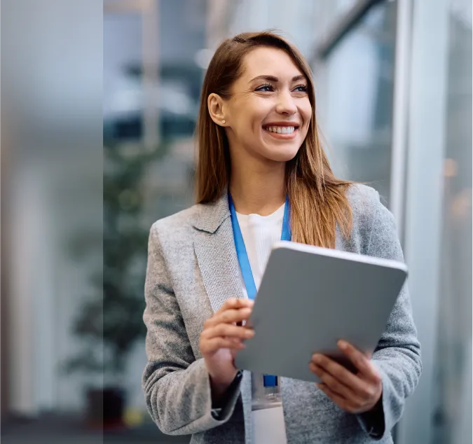 A smiling woman holding a clipboard in her hands.