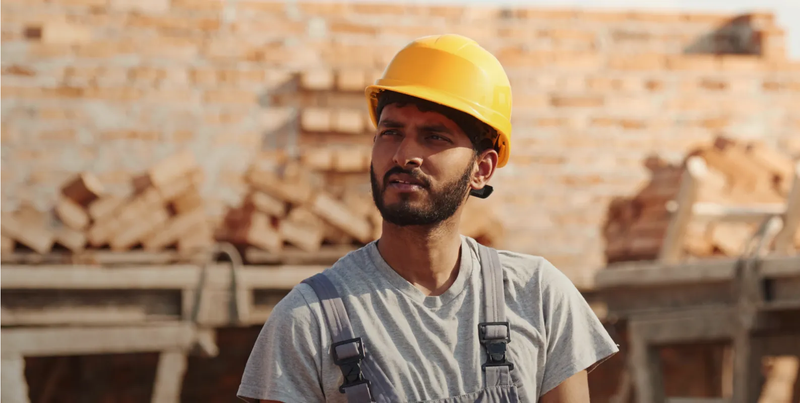 A man wearing a hard hat and overalls.