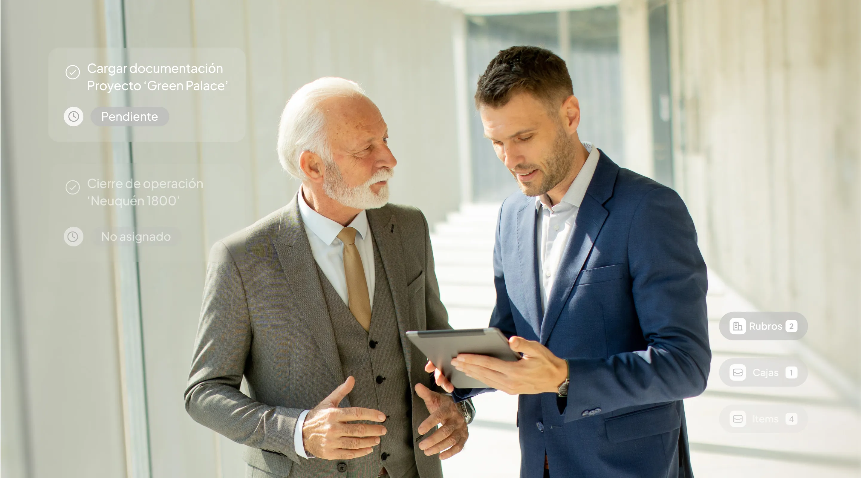 Two men in suits looking at a tablet.