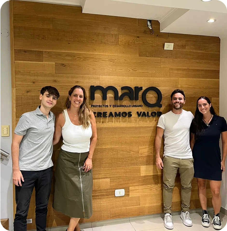 A group of people standing in front of a sign.
