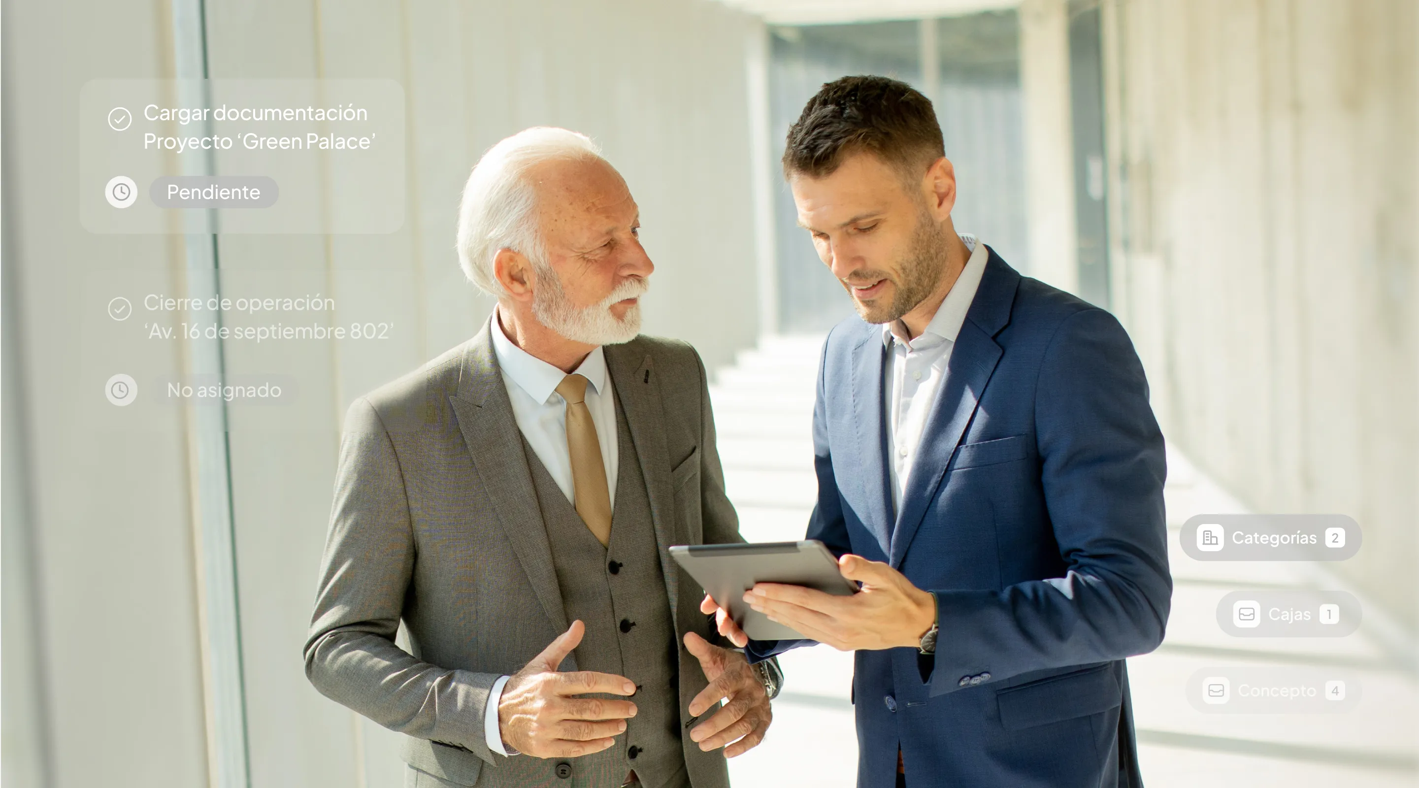 Two men in suits looking at a tablet.