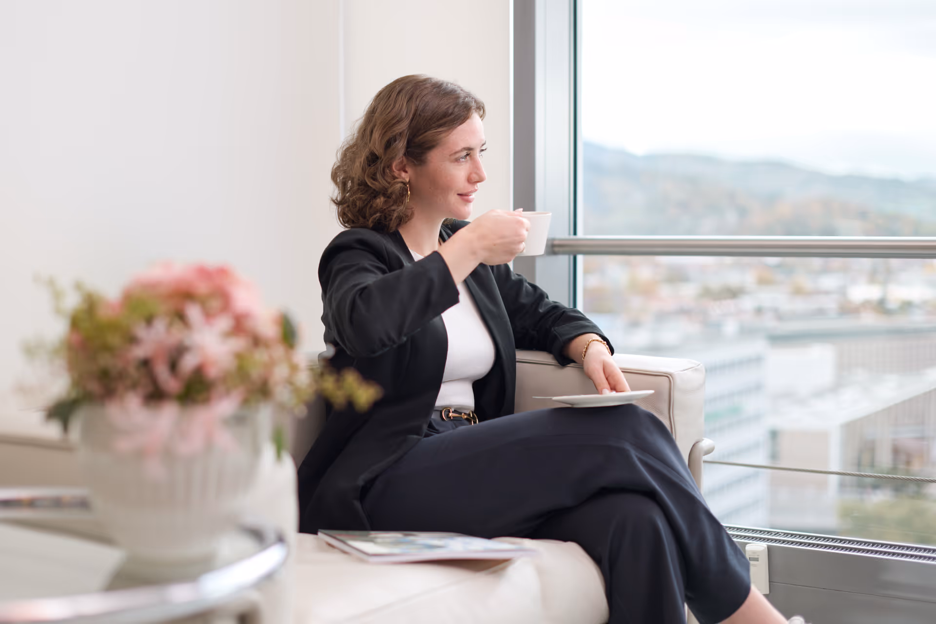 Frau trinkt Kaffee im Warteraum beim Zahnarzt