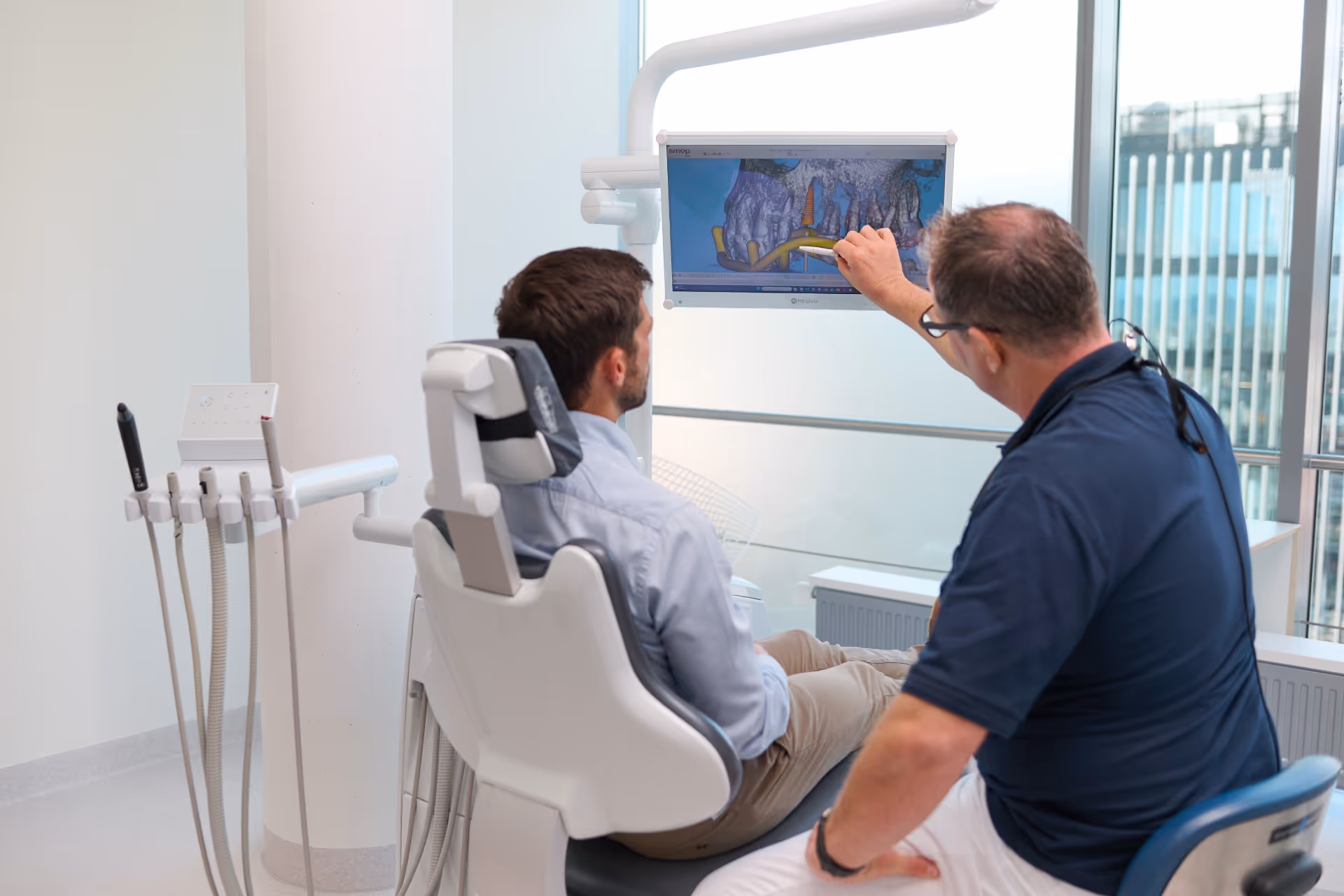 Behandler zeigt Zähne in der Implantatsoftware