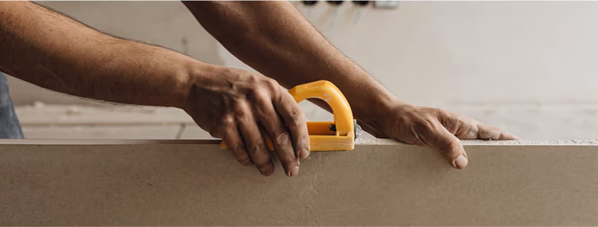 Photographie d'un homme qui découpe du parquet.