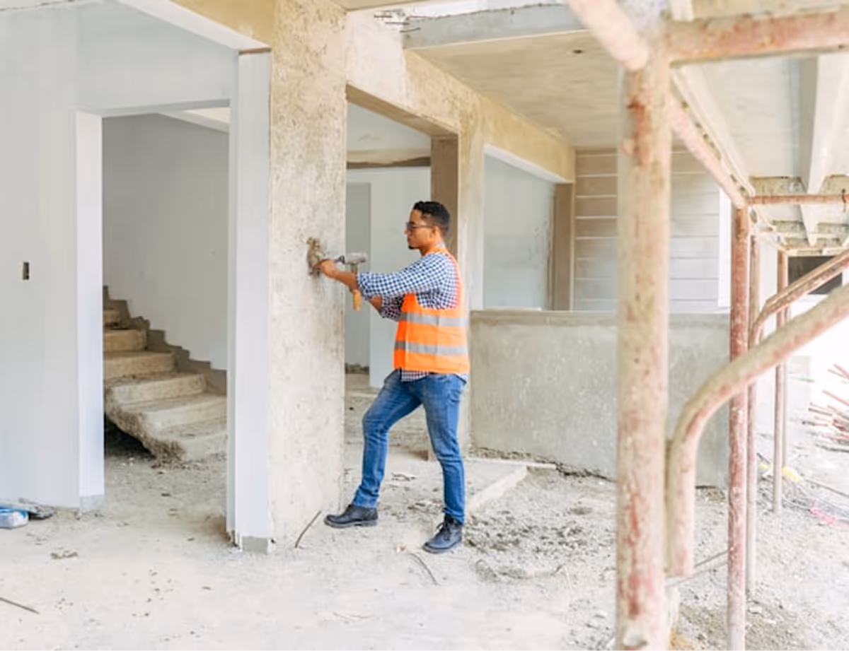 Photographie d'un homme qui rénove une maison.