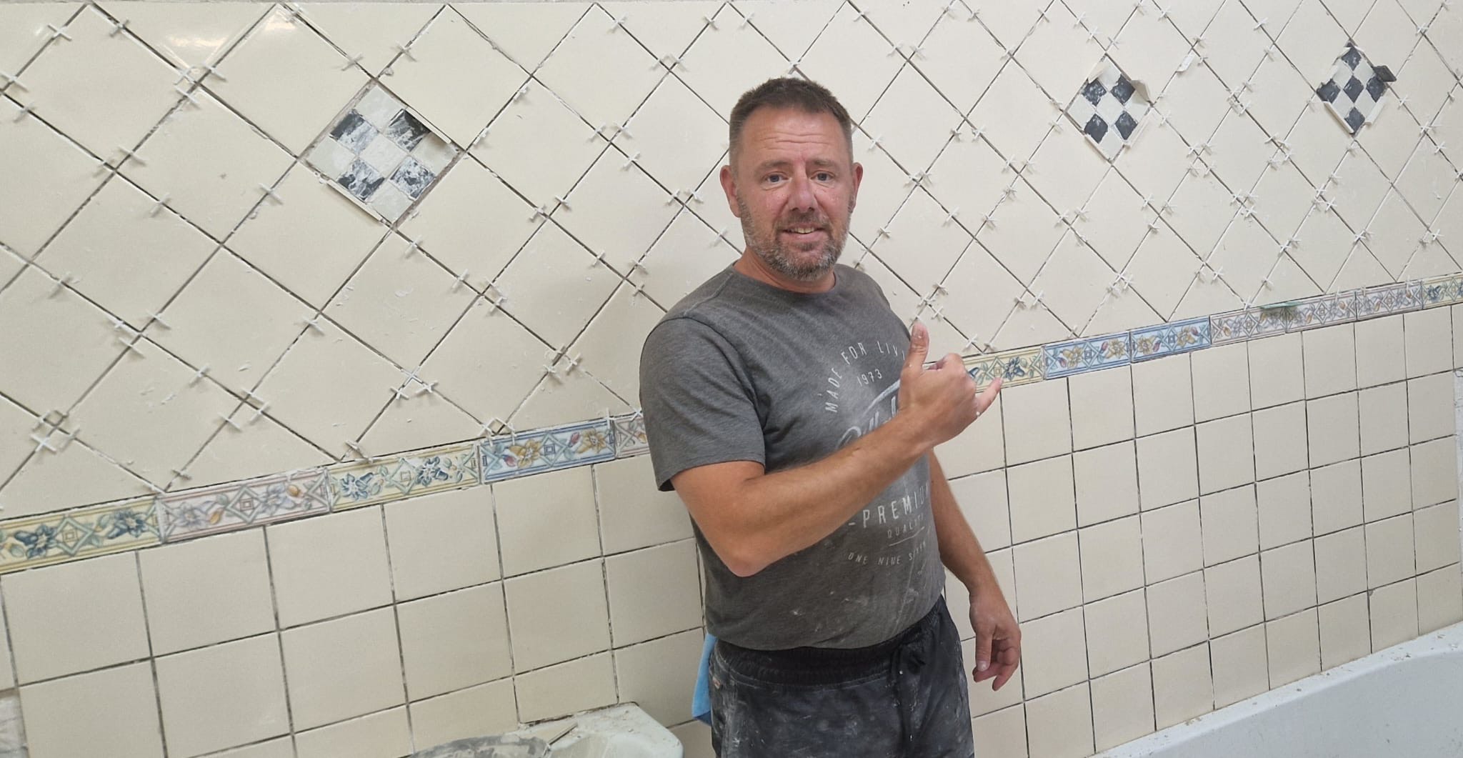 Owner of Tidal Tiling in Newquay, Cornwall, pictured in front of recently completed bathroom tile work. Skilled craftsmanship and local expertise you can trust.