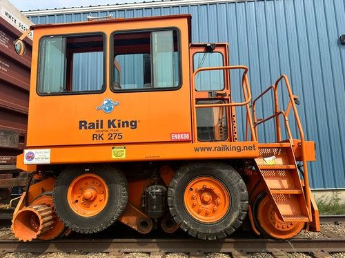 Side view of an orange Rail King RK 275 railcar with large tires
