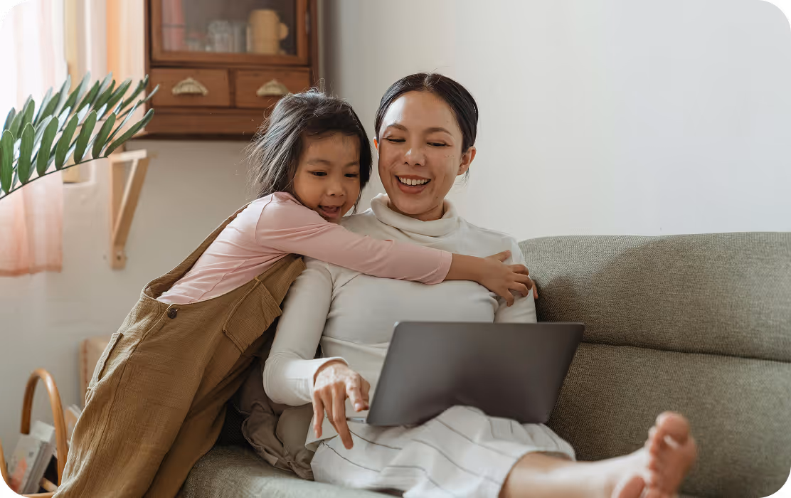 Work-from-home mother smiling and playing with her daughter