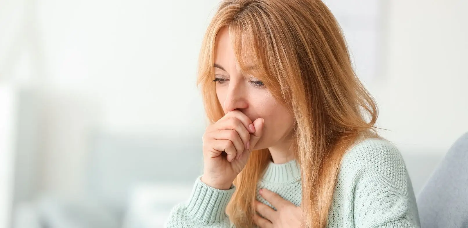 Photo of a woman coughing because of an allergy