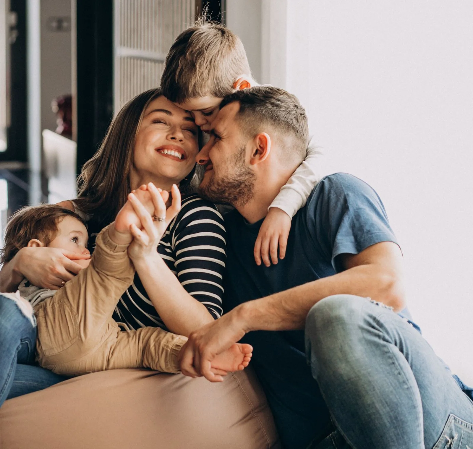 Family of four sharing a joyful moment indoors.