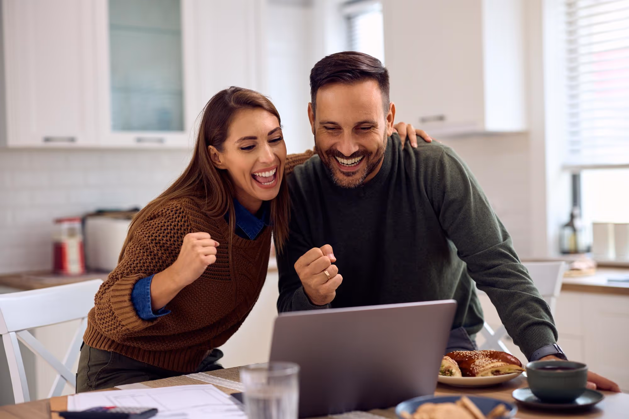 Couple looking at laptop and happy.