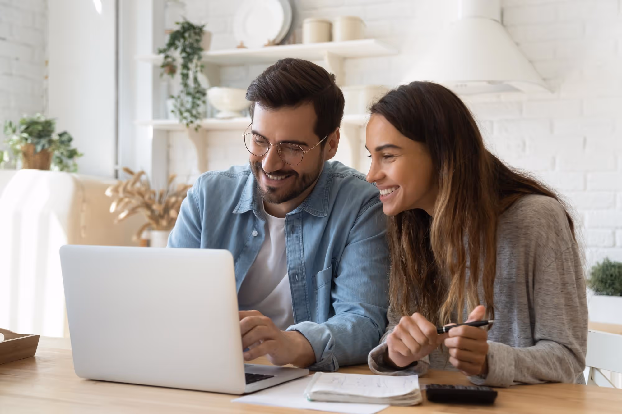Smiling couple using laptop to fill a online form.