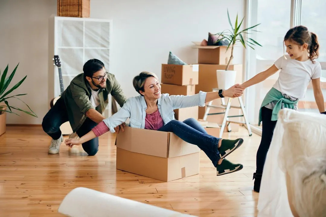 Happy family playing with a child in their new home.