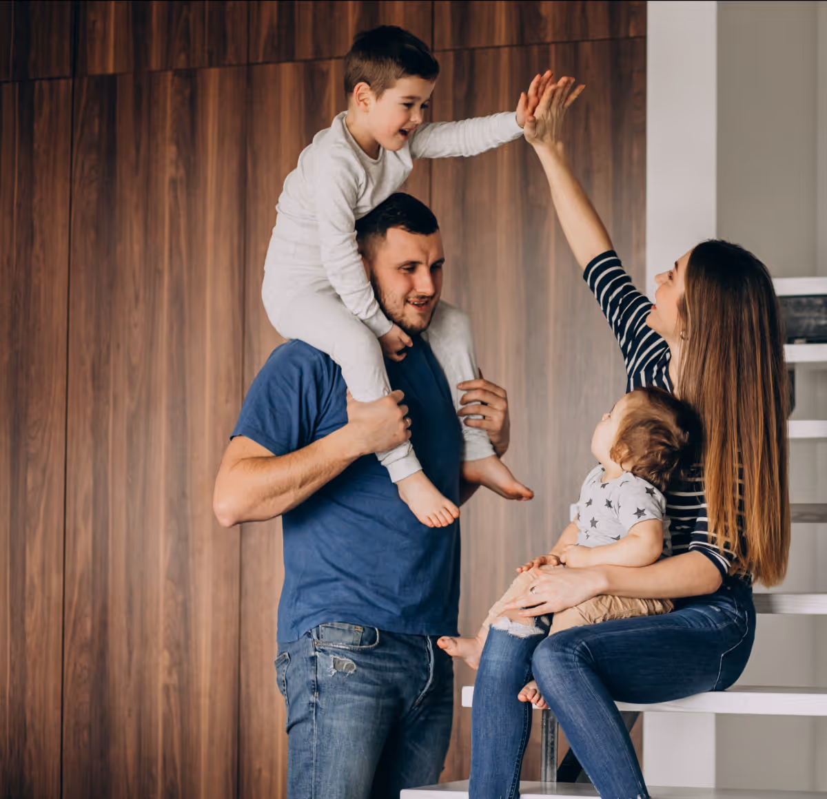 Family with two children playing and celebrating indoors.