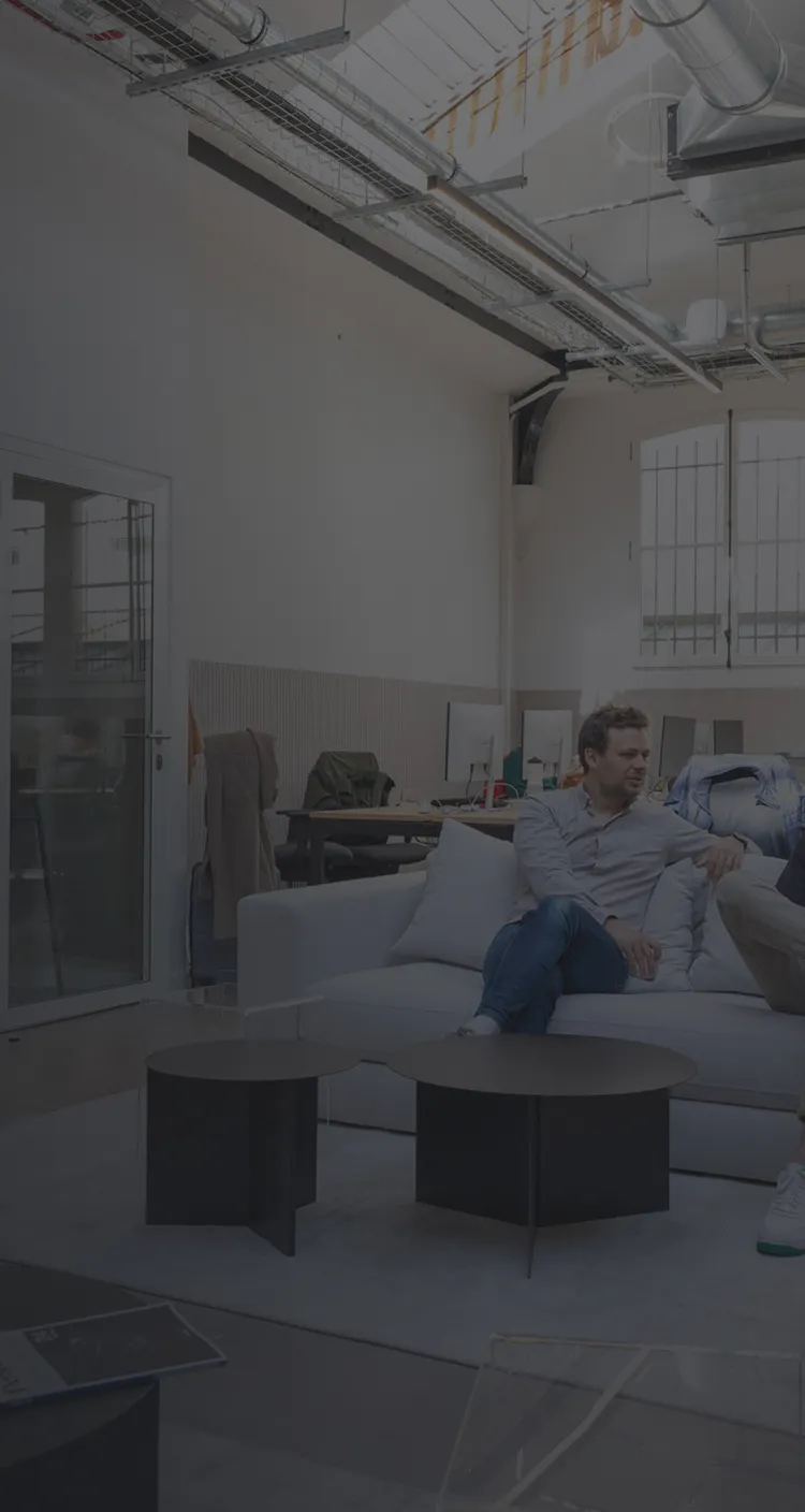 Two men sitting on a couch in a room.