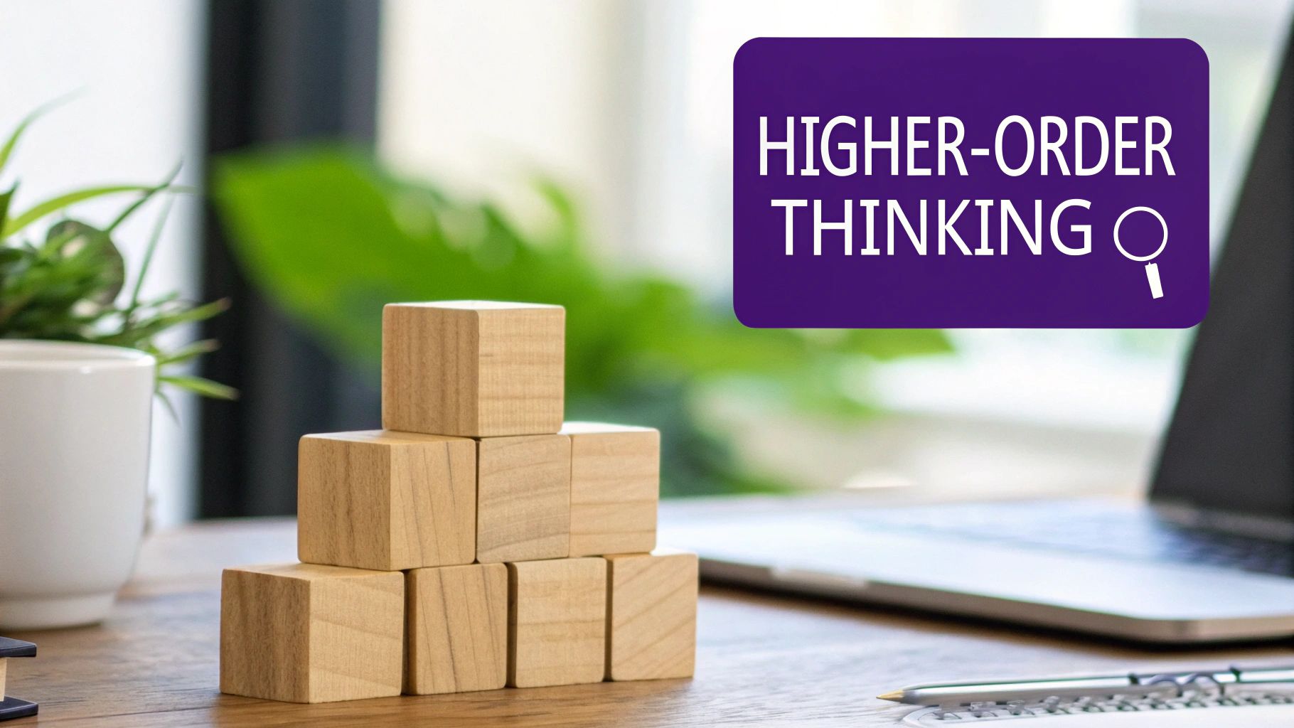 Wooden blocks arranged as steps on a desk with a laptop and a text bubble 'HIGHER-ORDER THINKING'.