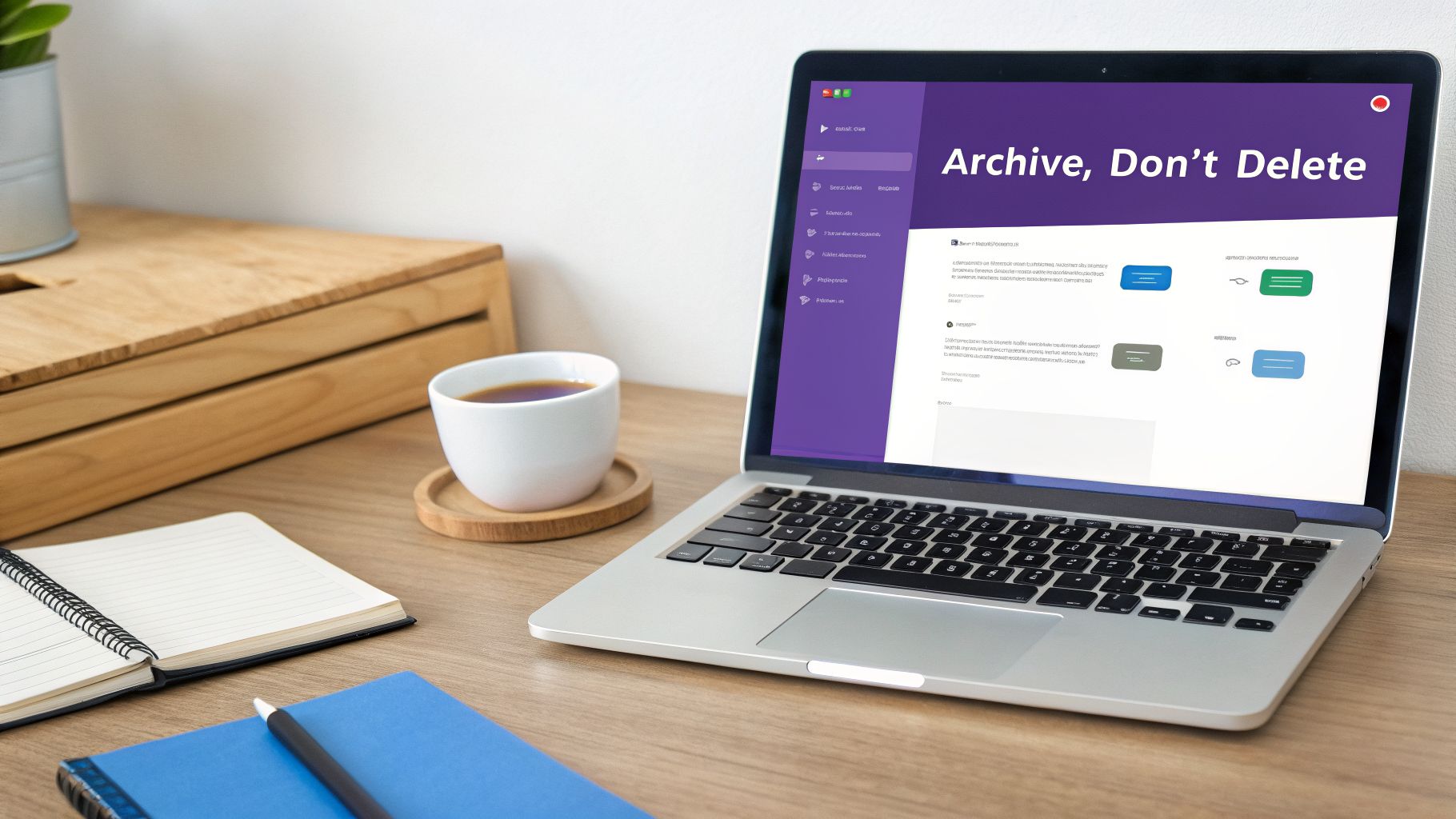 A laptop screen displays 'Archive, Don't Delete' on a wooden desk with coffee and notebooks.