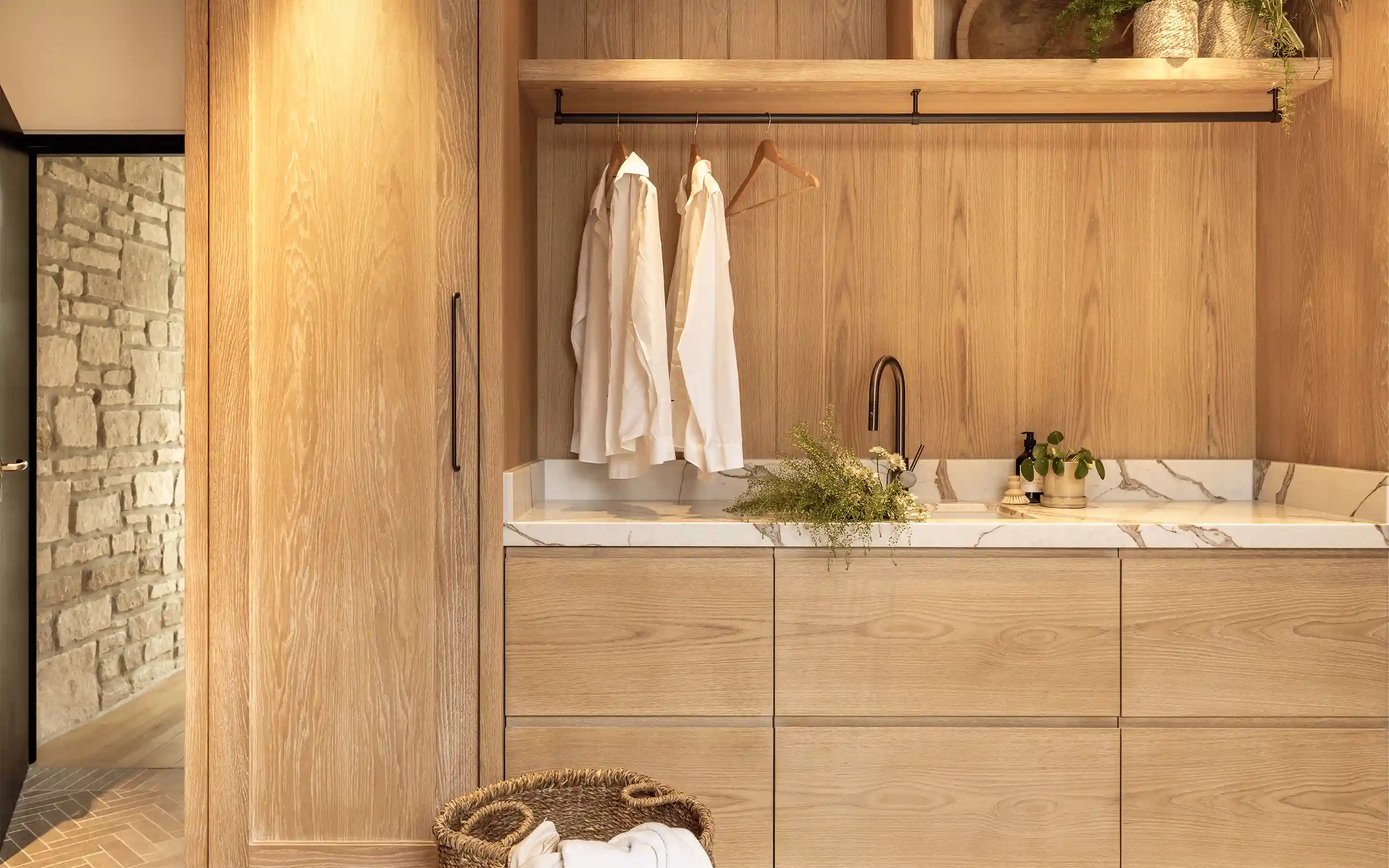 Bespoke timber utility space with integrated storage, stone worktop, and considered interior detailing in a Dorset private home