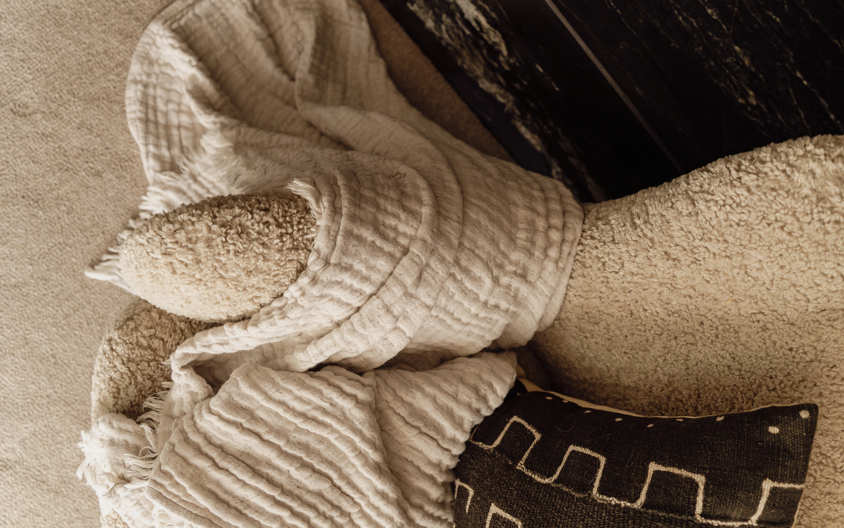 Layered cushions and textured throw styled on an upholstered armchair within a Dorset residential interior