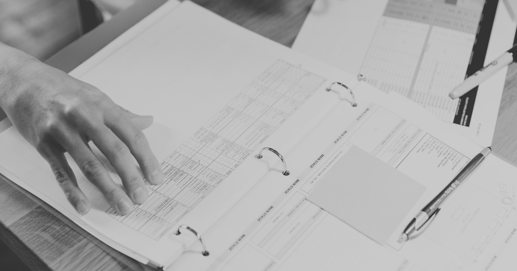 Construction programme schedule being reviewed with commercial fitout tender documents on a site desk