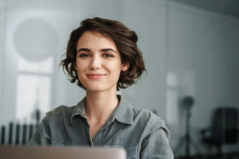 A woman smiling facing forward 