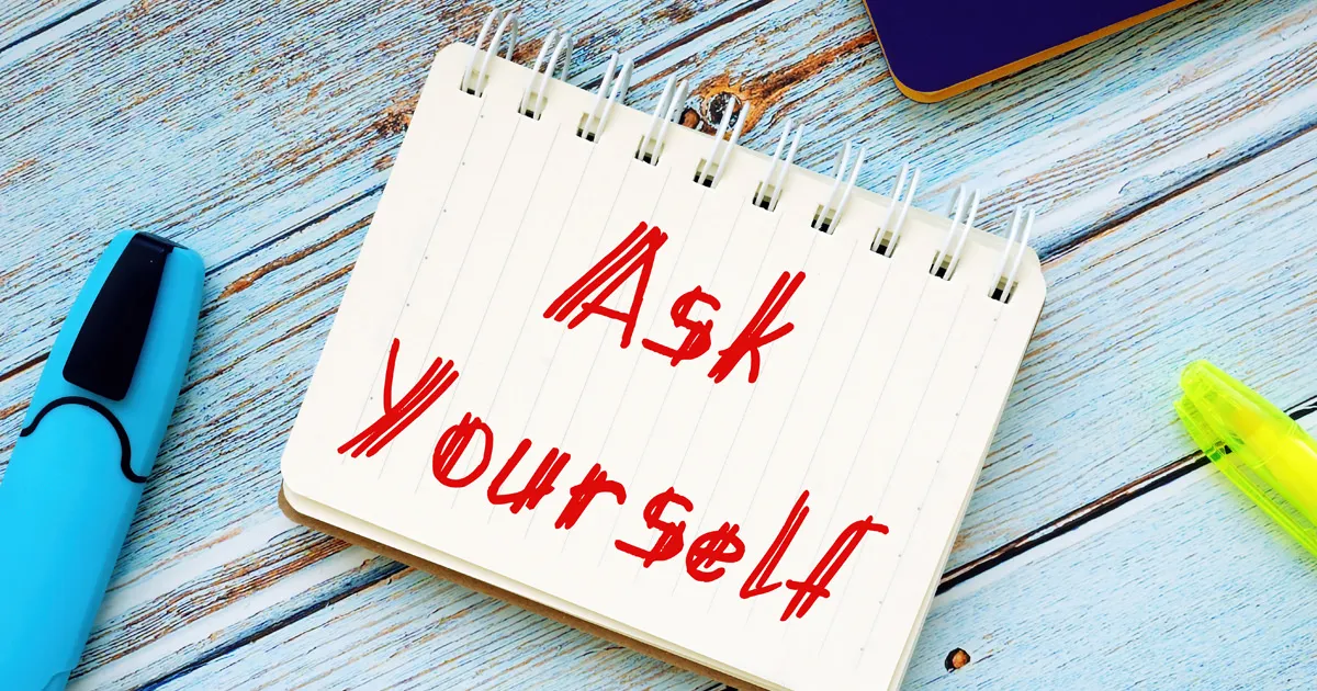 Pad on a wooden table with the wording "Ask Yourself" 