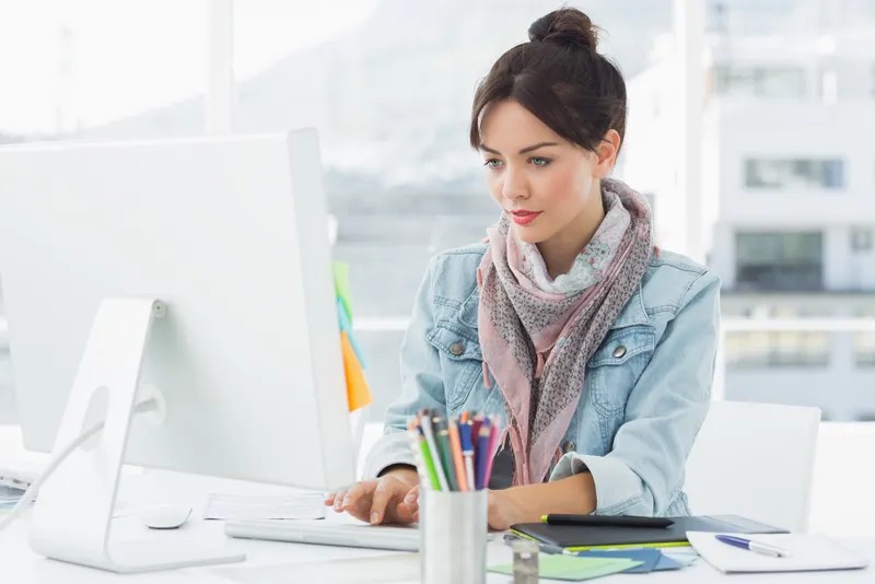 A woman in front of a computer monitor.