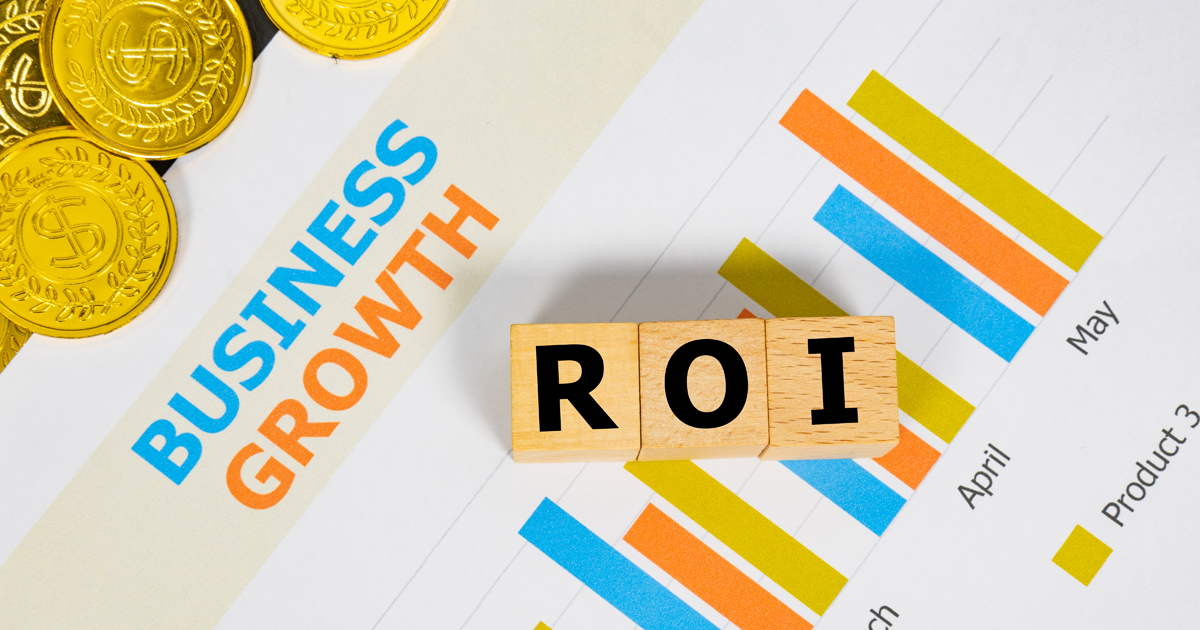 Three wooden blocks with the word ROI on a graph sheet with a pile of gold coins. Abbreviation for return on investment, growth business and investment. Business and financial market concept.