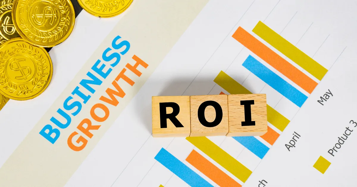 Three wooden blocks with the word ROI on a graph sheet with a pile of gold coins. Abbreviation for return on investment, growth business and investment. Business and financial market concept.