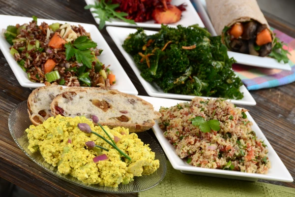 Schalen mit Salat, Couscous, Rührtofu und Gemüse