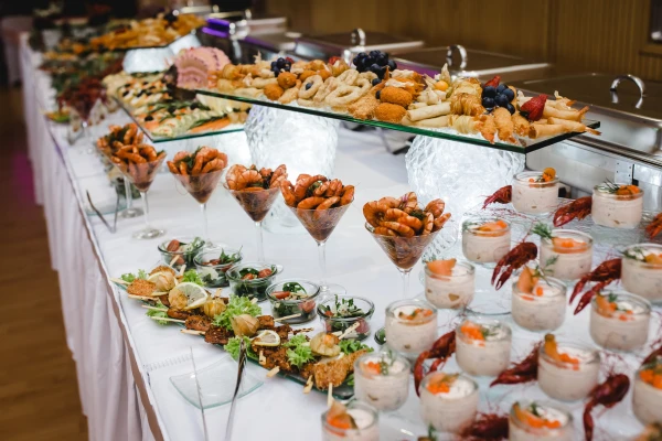 Langes Buffet mit Desserts in Gläsern und Platten mit Häppchen