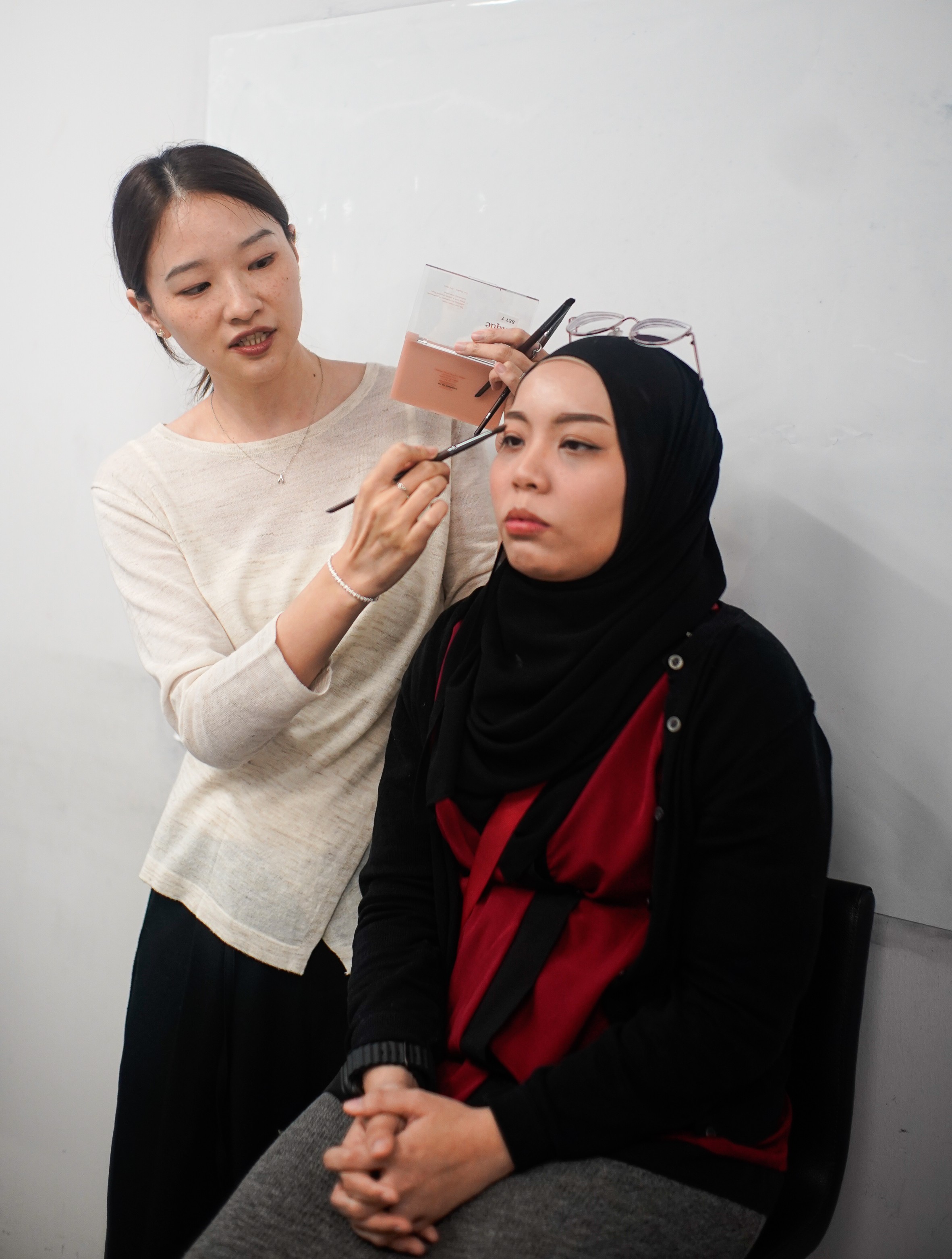 Instructor applying makeup on a participant during a makeup class in Singapore