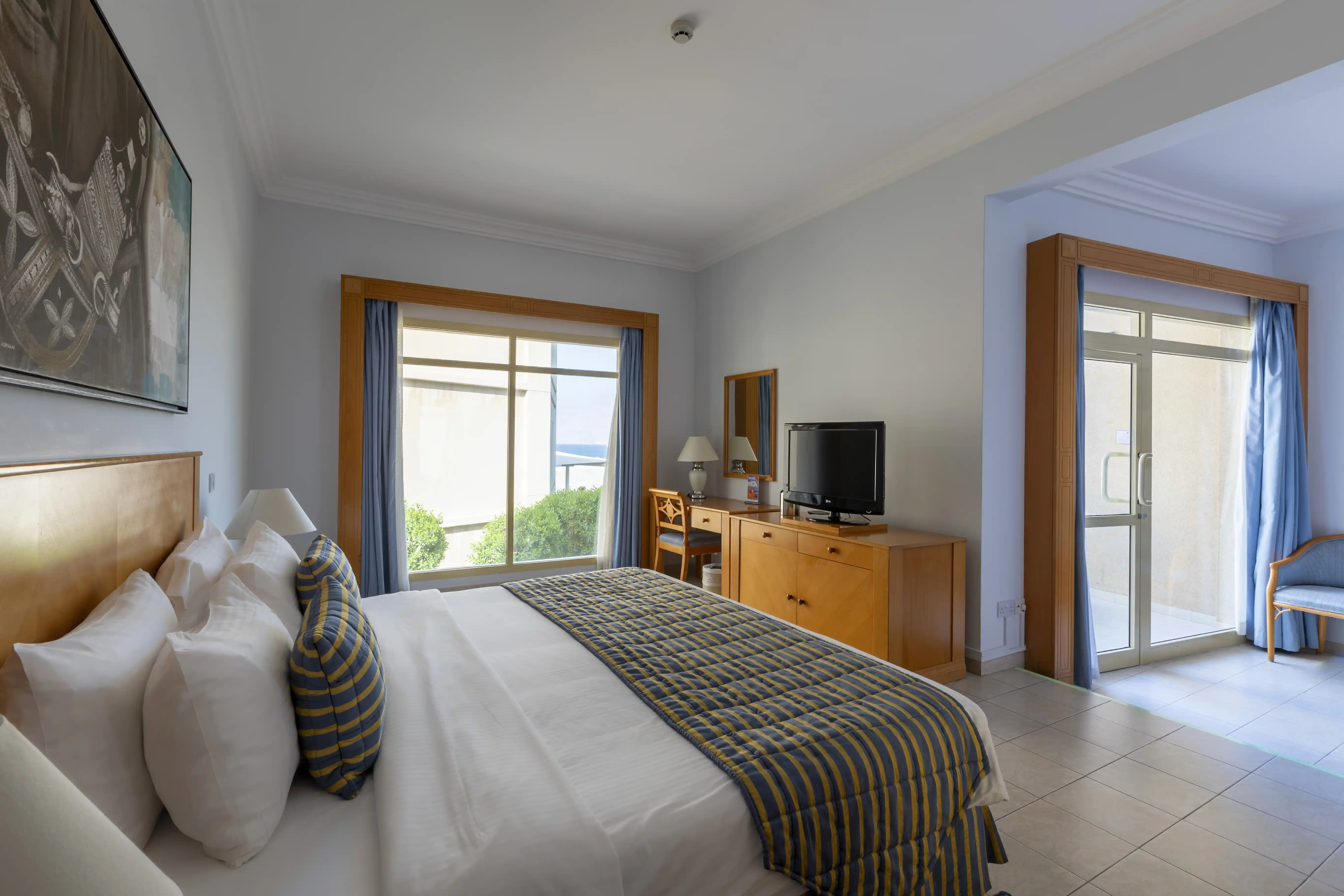 The King Chalet bedroom with an open doorway leading to a separate sitting area and the sea-view balcony.