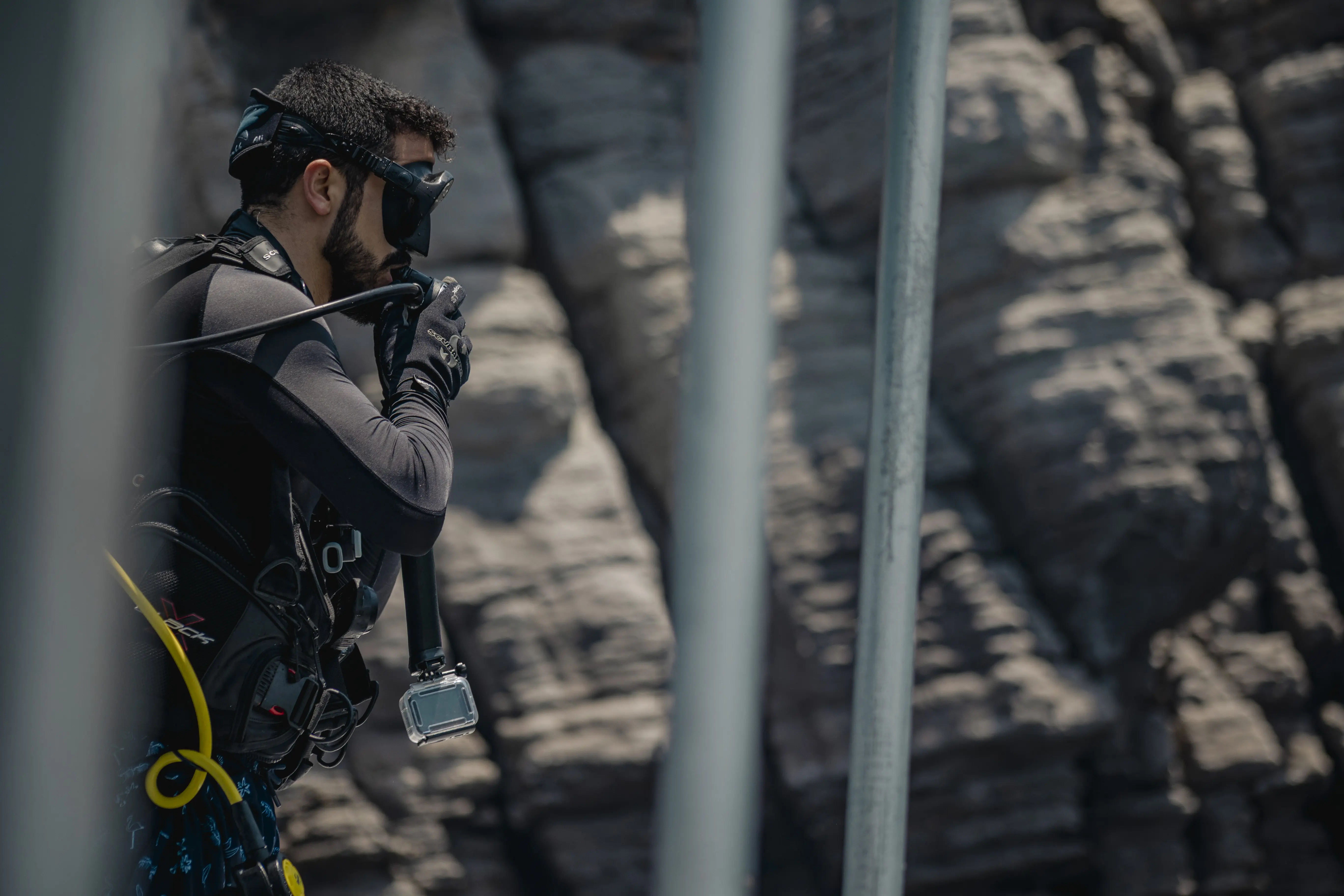 A scuba diver on a boat puts his regulator in his mouth, conducting final checks before a dive.