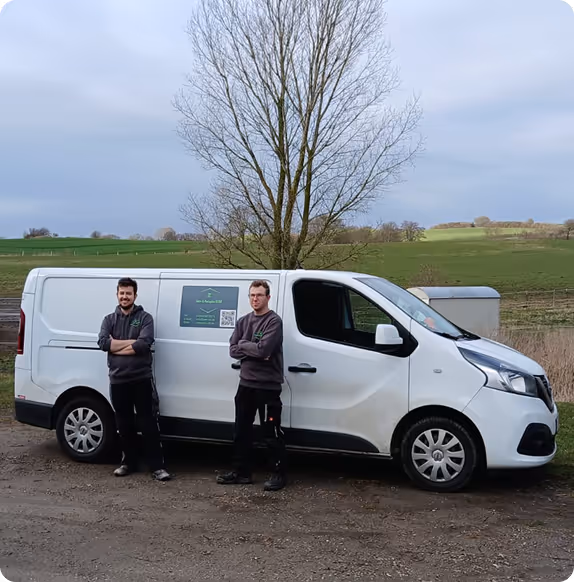 Zwei Männer stehen vor einem weißen Transporter mit einem Firmenlogo und QR-Code auf der Seite, im Hintergrund eine Baumlandschaft.