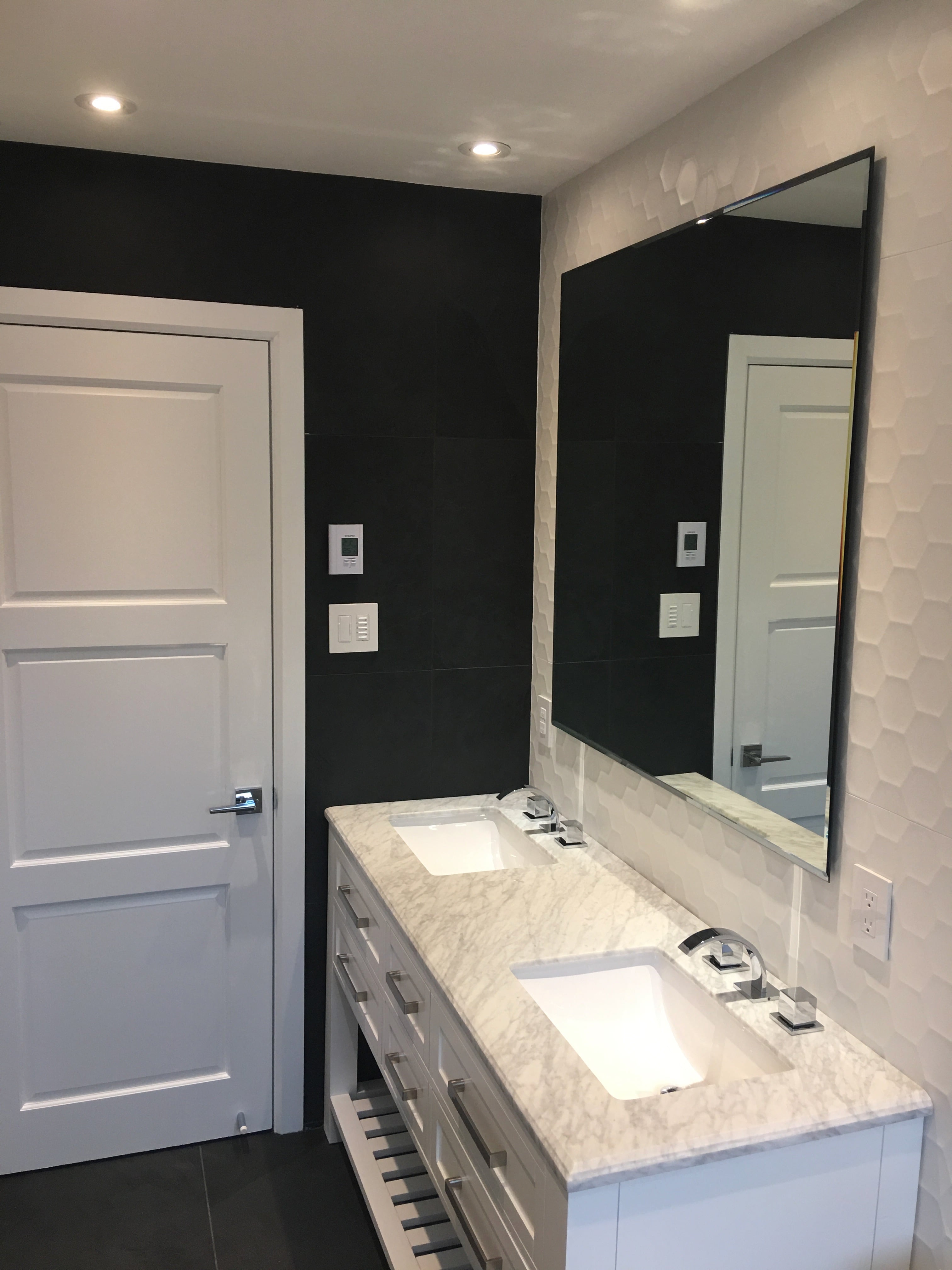 Clean modern bathroom with large mirror and soft lighting