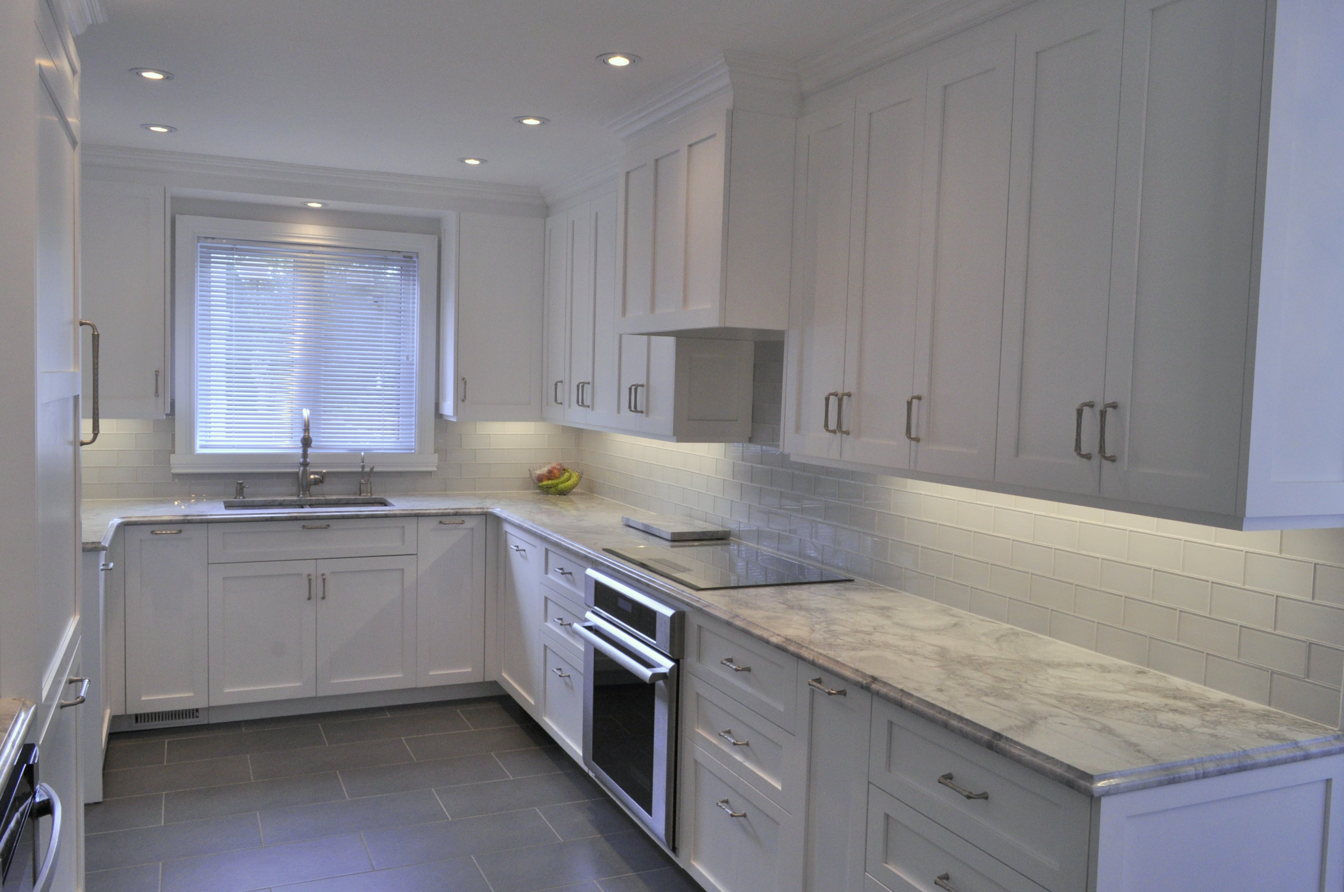 Renovated kitchen with hardwood flooring and range hood-min