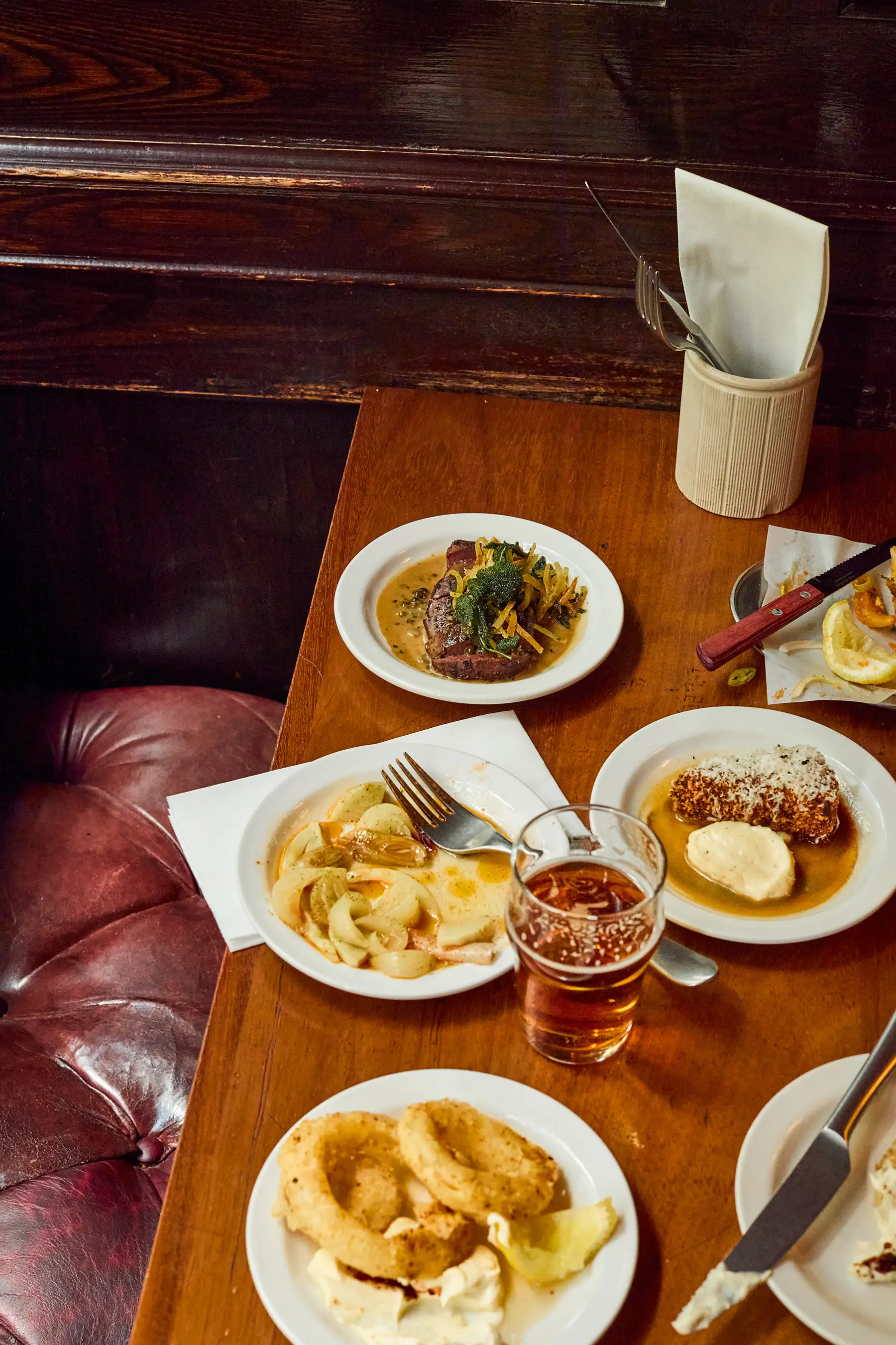 steak and chips, onion rings, vegetables and beer