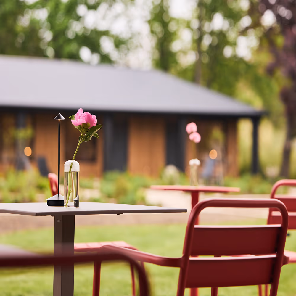 Close up view of floral arrangement on a red outdoor dining set