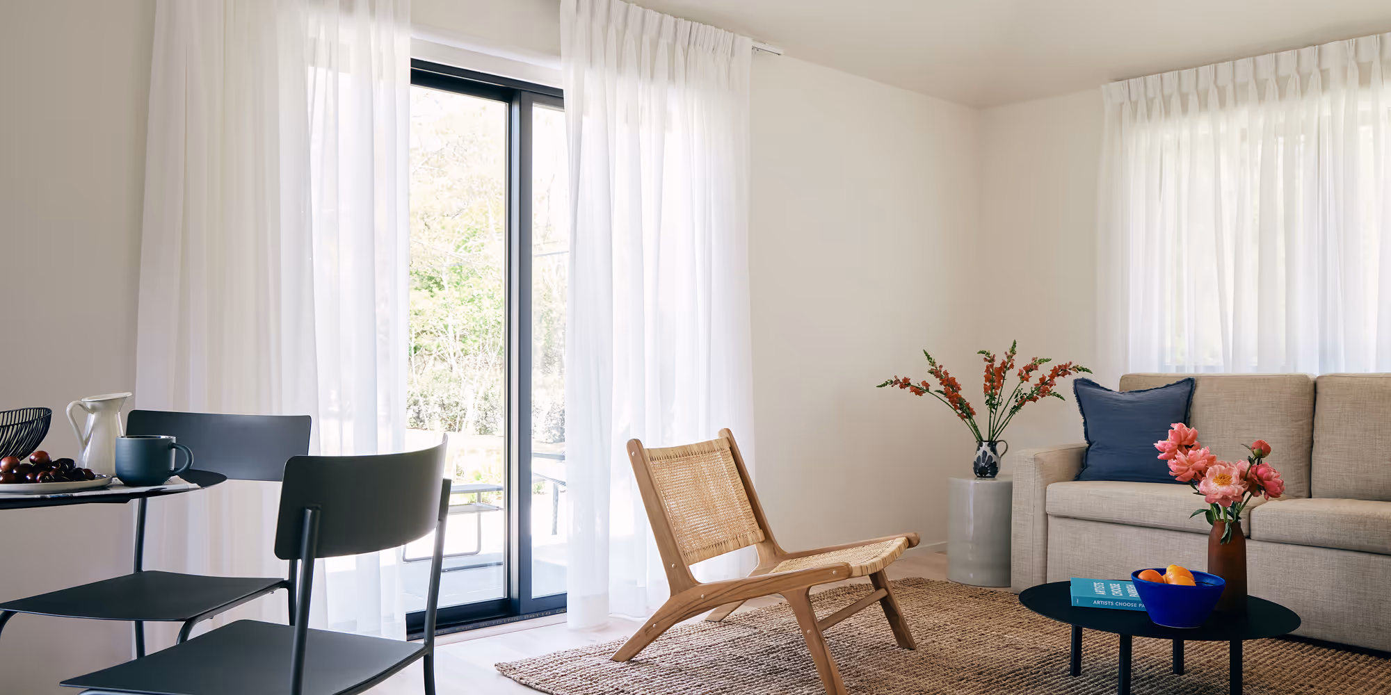 Suite living room with dining set, sliding glass doors and a couch, coffee table and chair