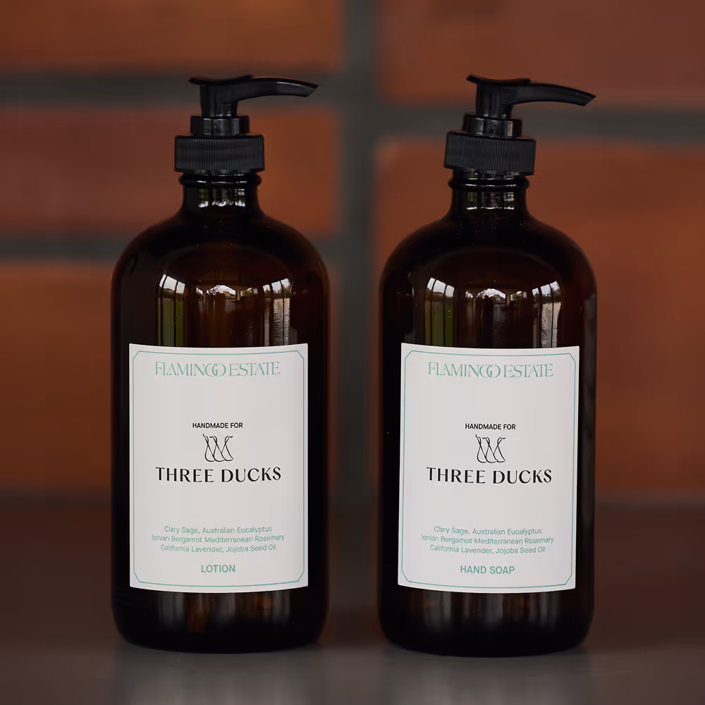 Two Flamingo Estate bottles of lotion in amber containers