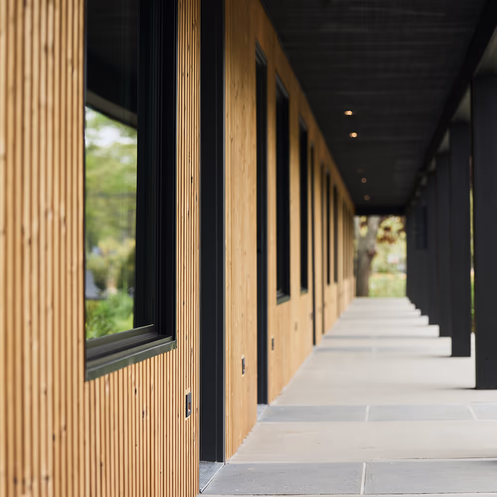 Outdoor hallway of wood panel hotel building with black accents