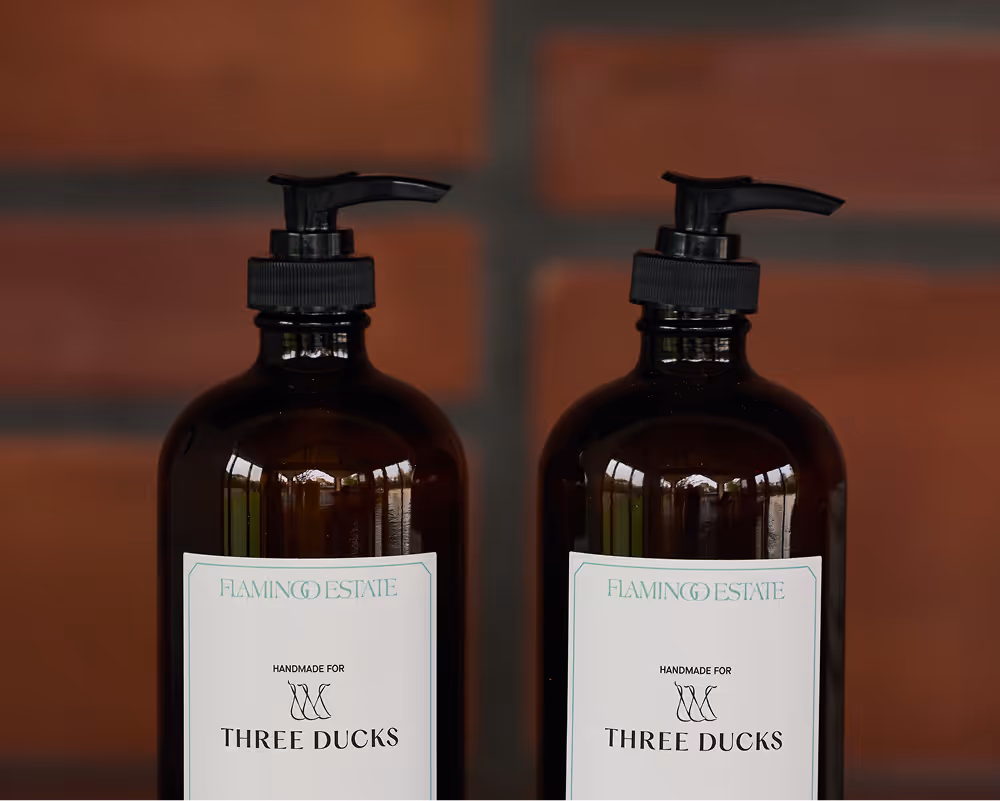 Two Flamingo Estate bottles of lotion in amber containers