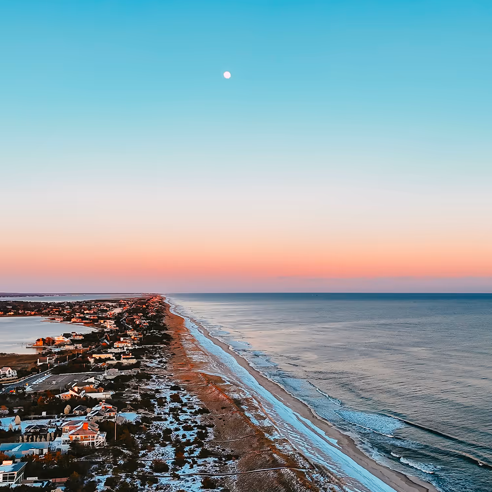 Houses along a beach coast at sunset