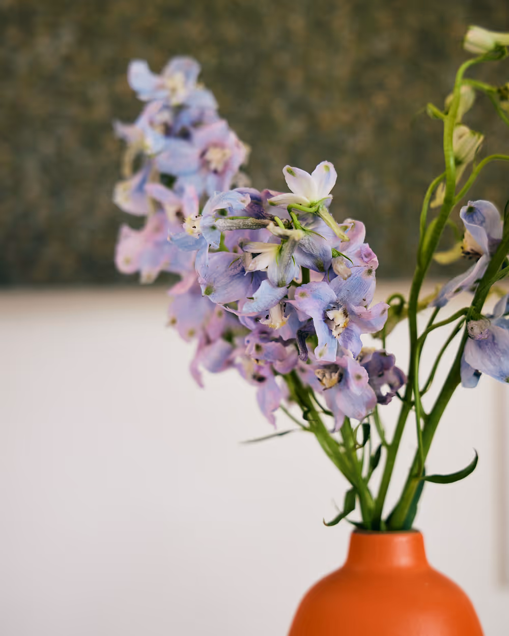 Light purple florals in a bright burnt orange vase