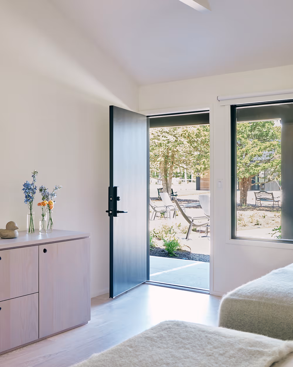 Angled view of two queen beds looking towards a wall with a door leading outdoors