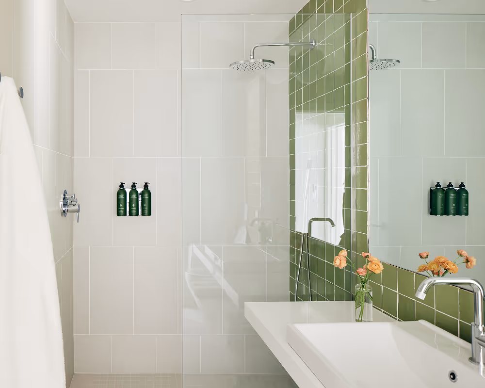 Bathroom with shower and sink, green tile feature wall