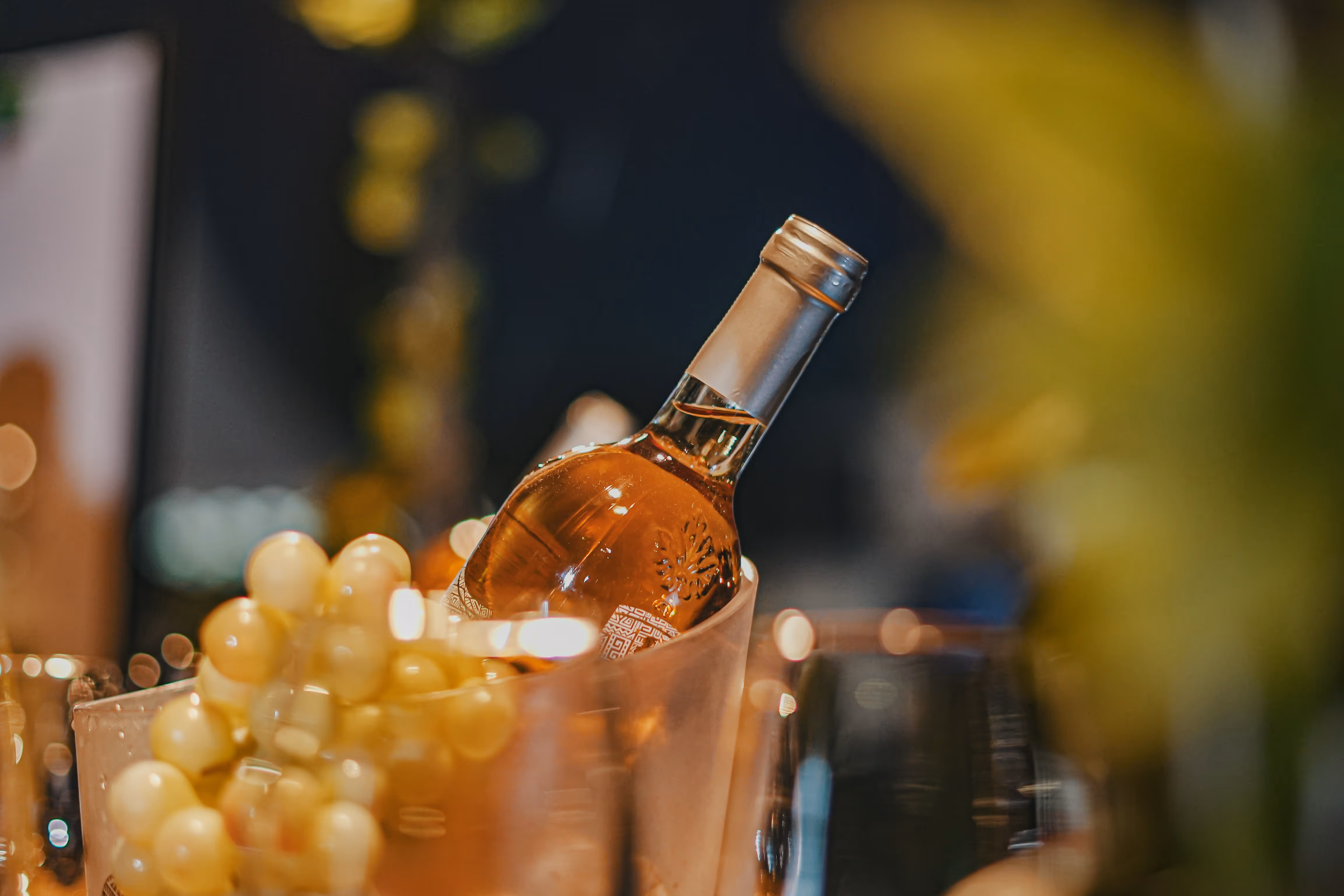 Wine bottle and green grapes in a copper bucket