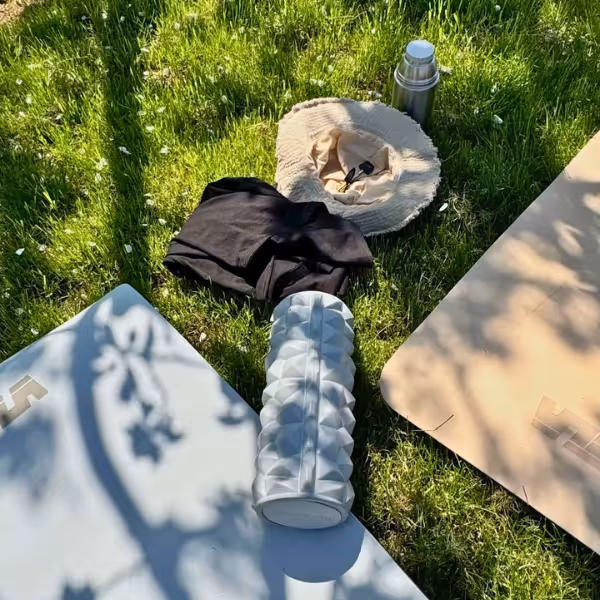 top down view of yoga mats with water bottle and bags on grass